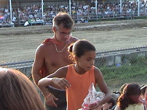 2005 Ford Excursion - Man and girl at an outdoor event with spectators in bleachers.