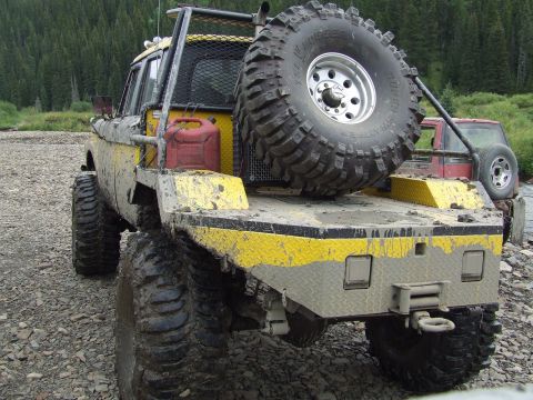 1990 Ford Bronco - Modified 1978 Ford Bronco flatbed with spare tire and jerry can, parked on a rocky surface.