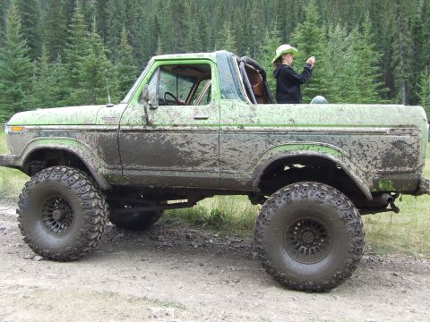 1990 Ford Bronco - This heavily modified SUV is covered in mud, suggesting it has been used for off-roading.