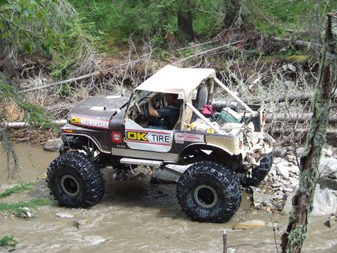 1990 Ford Bronco - This heavily modified Jeep CJ-7 navigates a rocky stream bed, its off-road capabilities.