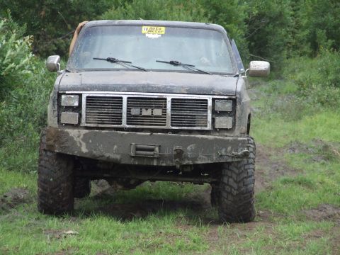 1990 Ford Bronco - This GMC pickup truck is covered in mud, suggesting it has been off-roading.
