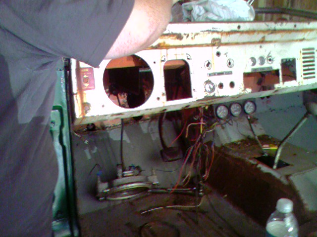 Dashboard panel removed from a vehicle, showing wiring and gauges