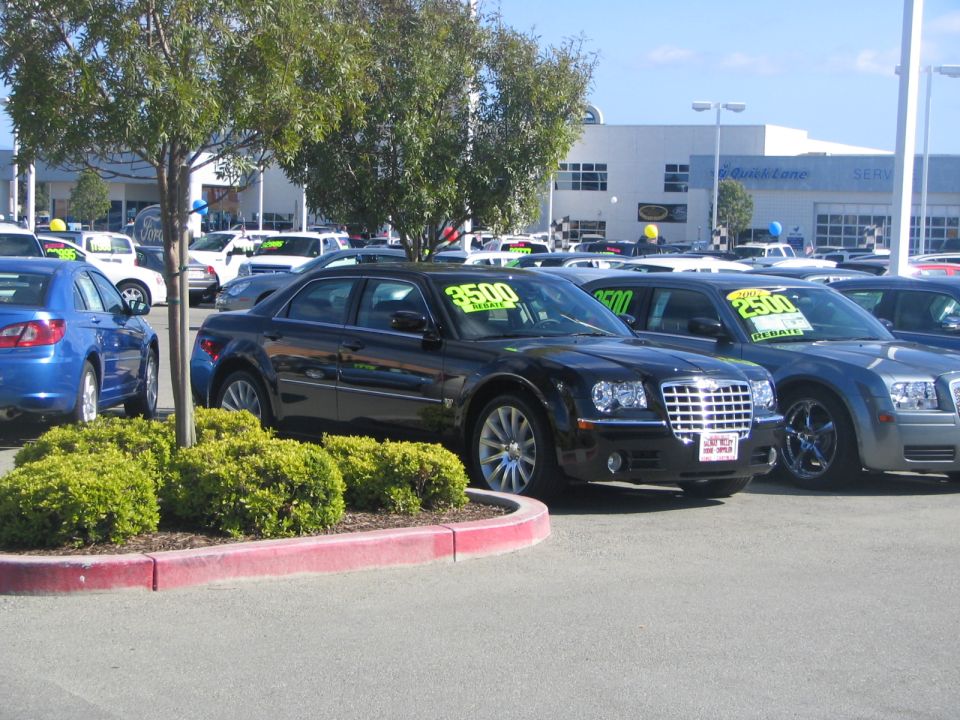 Black Chrysler 300 sedan with $3500 price tag on windshield, parked at dealership
