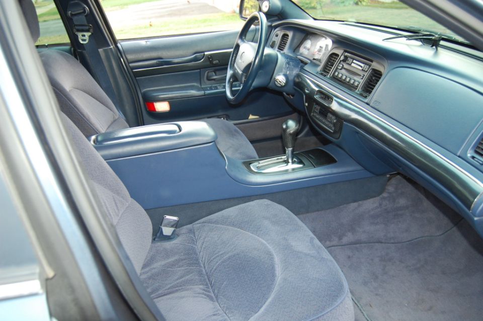 Blue cloth interior of a sedan with automatic shifter, dash, and steering wheel