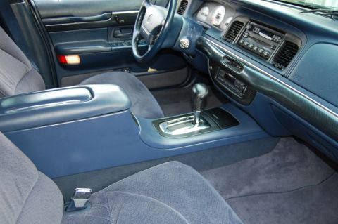 1985 Mercury Grand Marquis - The center console and dashboard of a blue car, likely from the mid-1990s, are visible in this interior shot.