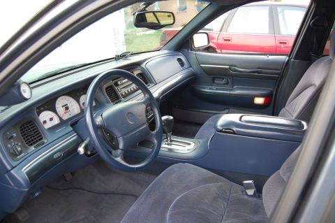 1985 Mercury Grand Marquis - Interior view of a car's dashboard and center console, with another vehicle seen through the side window.