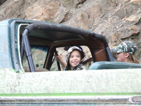 1988 Ford Bronco - Children enjoy a ride in a , weathered off-road vehicle, possibly on a trail.