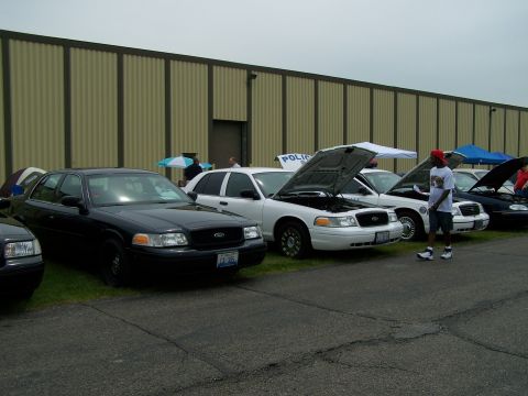 2003 Ford Crown Victoria - A line of Ford Crown Victoria police cars parked outside a building.