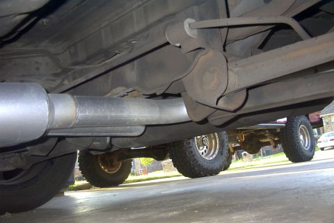 1994 Dodge Stealth - The underside of a vehicle reveals a recently installed exhaust system, with another vehicle partially visible behind it.