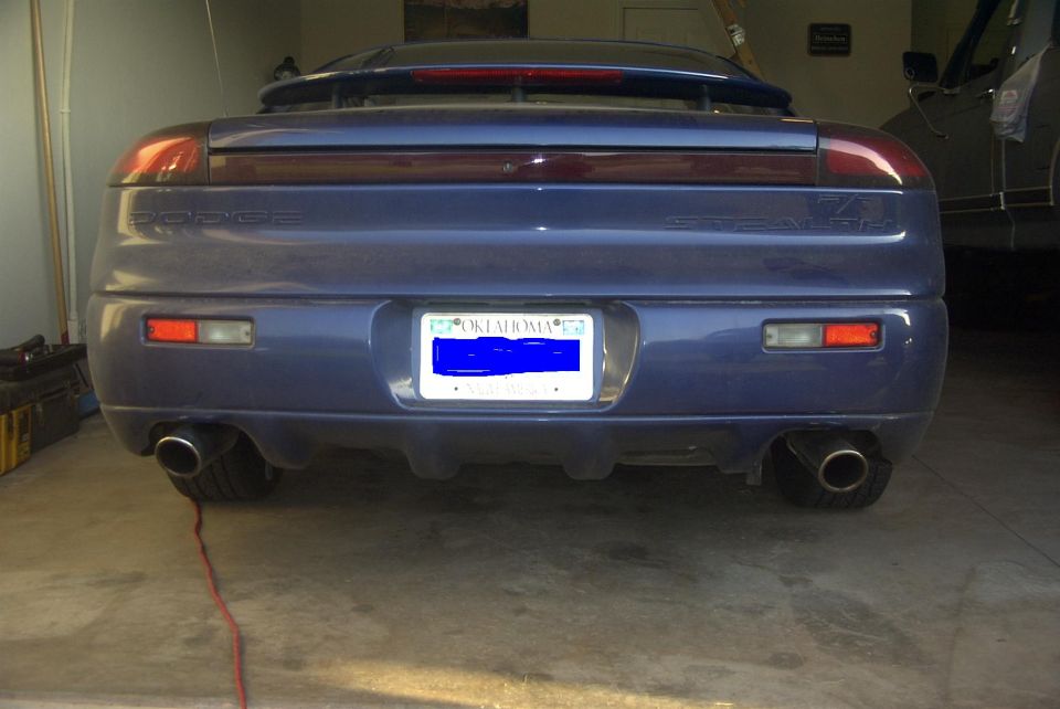 Rear view of a blue 1994 Dodge Stealth with an Oklahoma license plate and dual exhaust tips