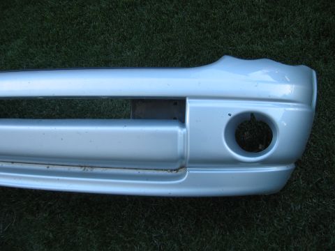 2005 Dodge 3500 - A silver front bumper with a circular opening for a fog light is shown against a grassy background.