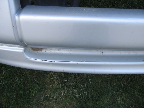 2005 Dodge 3500 - Silver bumper part shows a significant crack along its lower edge.