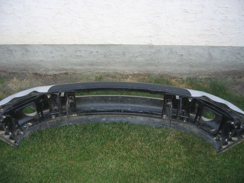 2005 Dodge 3500 - A vehicle's front bumper assembly is shown resting on grass in front of a textured wall.