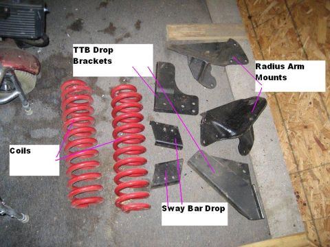 1995 Ford Bronco - Various vehicle suspension components are laid out on a concrete floor, with labels pointing to specific parts.