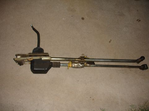 1993 Ford Taurus - Manual transmission shifter assembly, likely for an older vehicle, shown on a concrete surface.