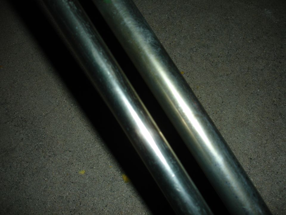 Two metal pipes on a textured surface