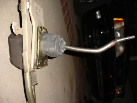 1993 Ford Taurus - Close-up of a car part, possibly a shifter linkage, with a rubber boot and metal rod.