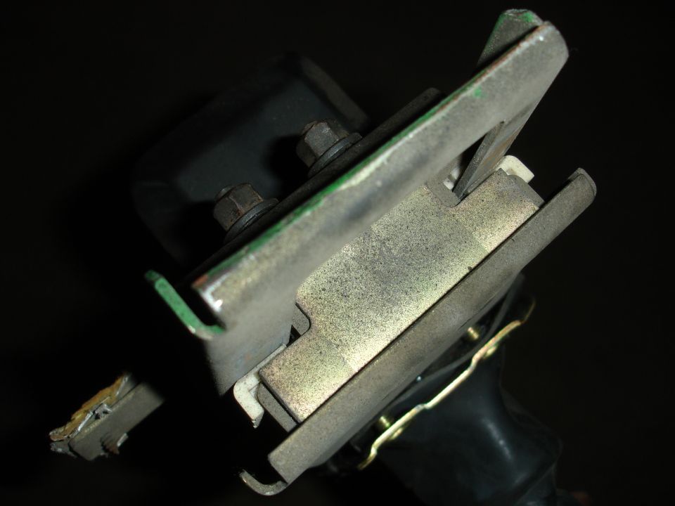 Close-up of a metal bracket with bolts and a black rubber component