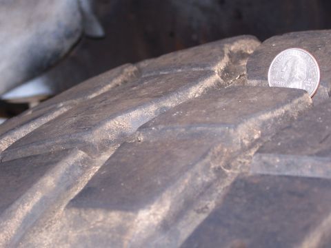 2007 Ford Bronco - Close-up of a tire tread with a quarter placed on it to show scale. The tread appears worn.