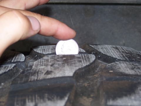 2007 Ford Bronco - Checking tire tread depth with a quarter coin.