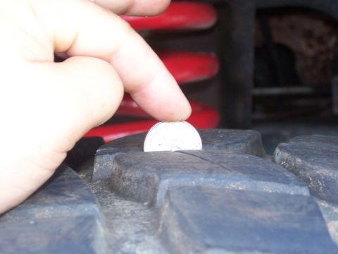 2007 Ford Bronco - A quarter is used to gauge the tread depth of a vehicle's tire.