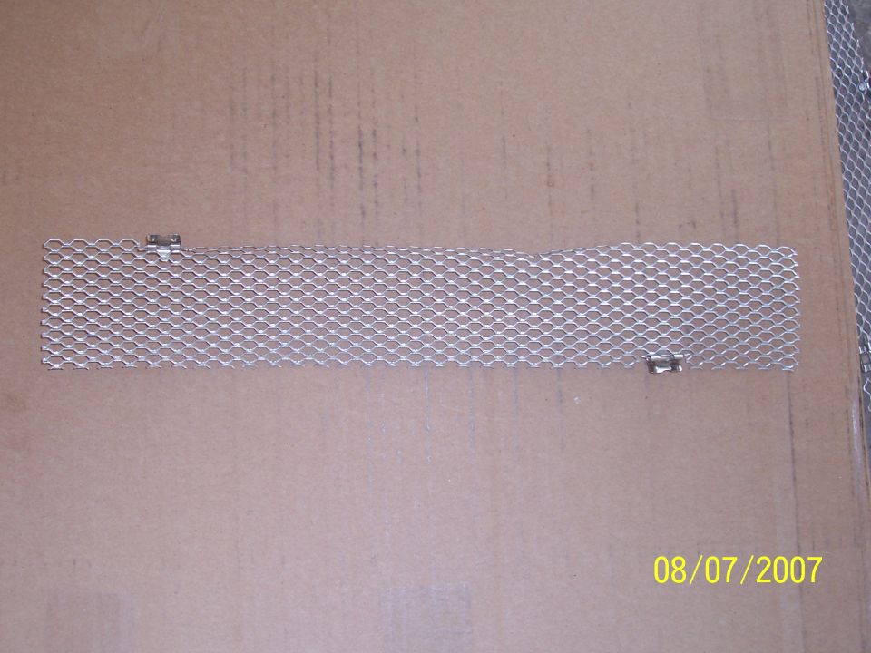 Narrow silver expanded metal mesh grille insert with mounting tabs on cardboard, dated 08/07/2007