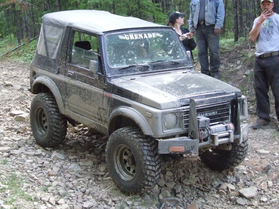 Suzuki Samurai with a soft top on a rocky trail. Text on windshield reads 'GRENADE'