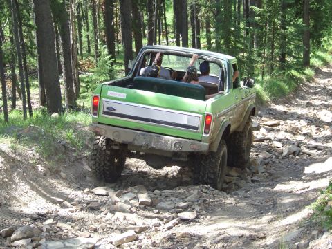 1990 Ford Bronco - This 1978 Ford Bronco navigates a challenging rocky path through a wooded area.