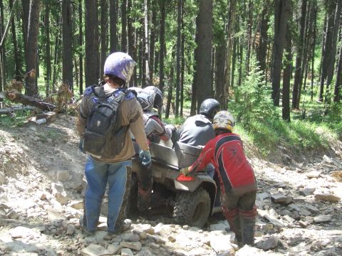 1990 Ford Bronco - ATV riders on a challenging trail in a wooded area.
