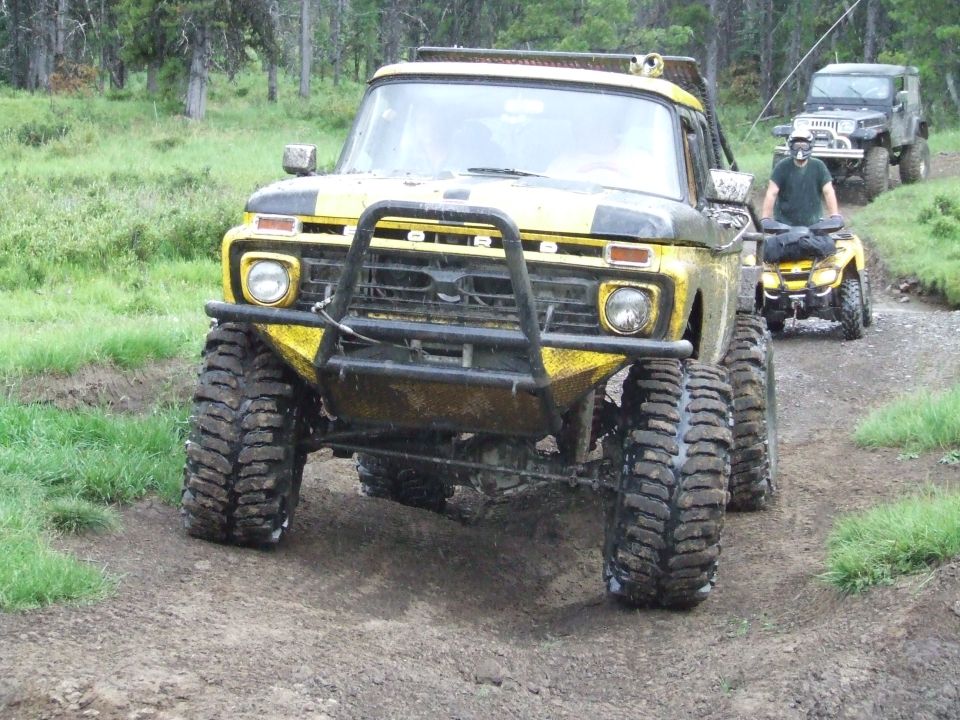 Yellow off-road truck with brush guard and large tires