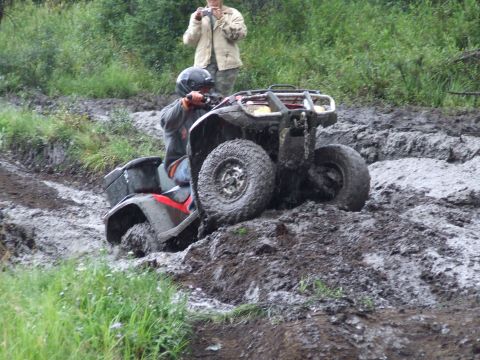 1990 Ford Bronco - An ATV navigates a muddy trail, getting stuck in the mire.