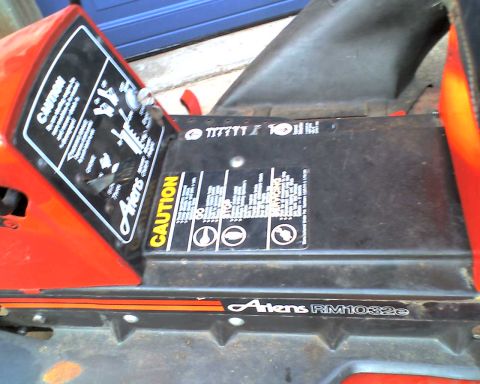 1965 Ford Mustang - The control panel of an Ariens lawnmower shows caution labels and operational instructions.
