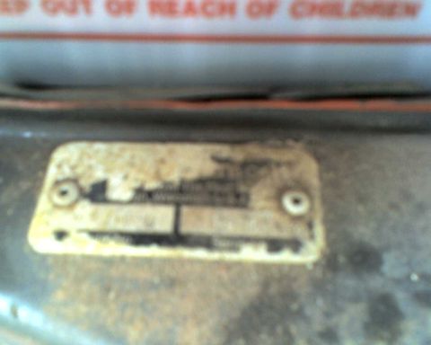 1965 Ford Mustang - A close-up of a worn vehicle identification plate, with text partially visible.