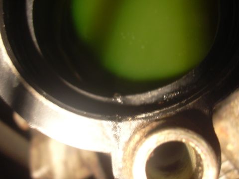 1997 Ford Crown Victoria - A close-up view of a vehicle's engine part, showing a dark opening and green fluid.
