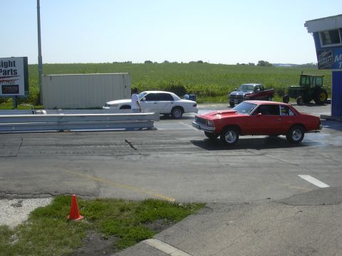 1997 Ford Crown Victoria - Multiple vehicles are present at a drag strip, including a red coupe and a white sedan.