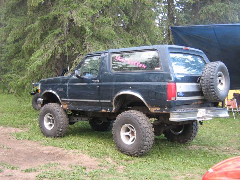 1995 Ford Bronco - This lifted 1995 Ford Bronco has a spare tire mounted on the rear door and a pink decal on the window.