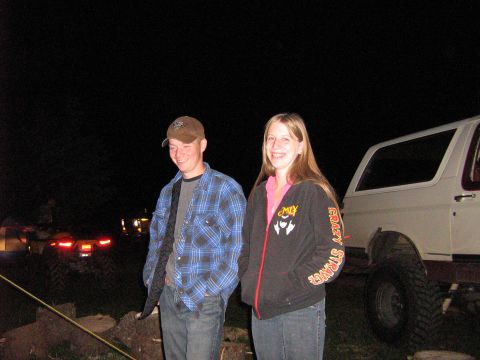 1995 Ford Bronco - Two people pose next to a lifted 1995 Ford Bronco at night.