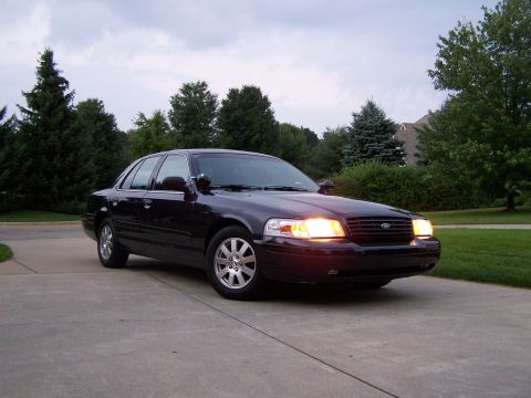 2003 Ford Crown Victoria - Front 3/4 view of a 2003 Ford Crown Victoria sedan parked outside.