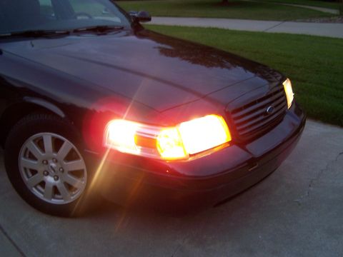 2003 Ford Crown Victoria - Front corner view of a dark 2003 Ford Crown Victoria, showing the headlights and grille.