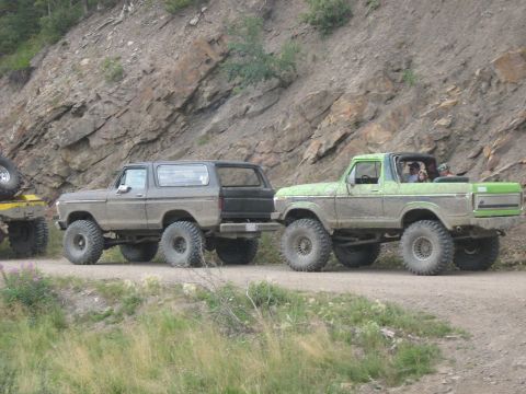 1995 Ford Bronco - Two lifted Ford Broncos, one grey and one green, are seen on a dirt road during the Rocky Mountain Bronco Rally in 2007.