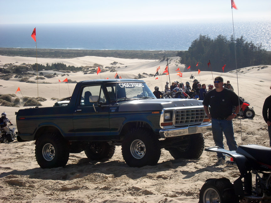 1979 Ford Bronco 3q-front view on sand dunes with ocean in background