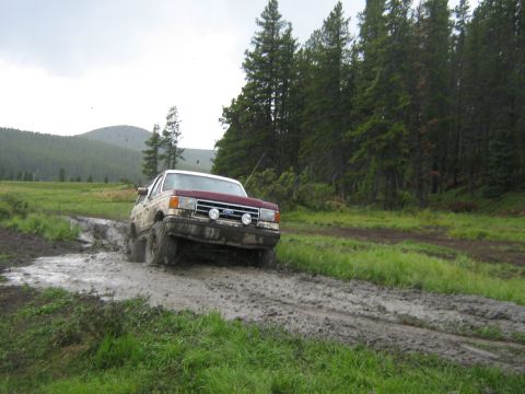 1995 Ford Bronco - This Ford Bronco tackles a challenging muddy terrain, its off-road capabilities.