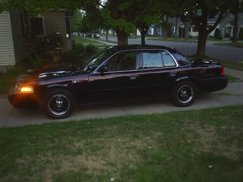 2000 Ford Crown Victoria - This black 2000 Ford Crown Victoria sedan is parked on a residential street.