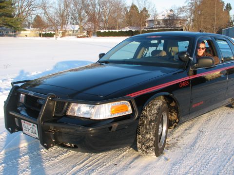 2000 Ford Crown Victoria - 2000 Ford Crown Victoria with a push bar and red stripe, seen in a snowy environment.
