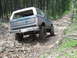 1988 Ford Bronco - A gray Ford Bronco navigates a rocky trail through a wooded area.