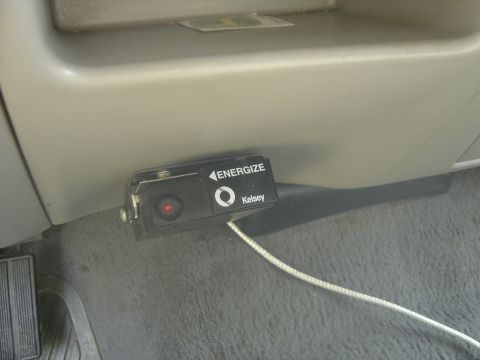 1988 Ford Bronco - A Kelsey electric trailer brake controller mounted under the tan dash of a truck interior, its black housing marked 'ENERGIZE' with an arro…