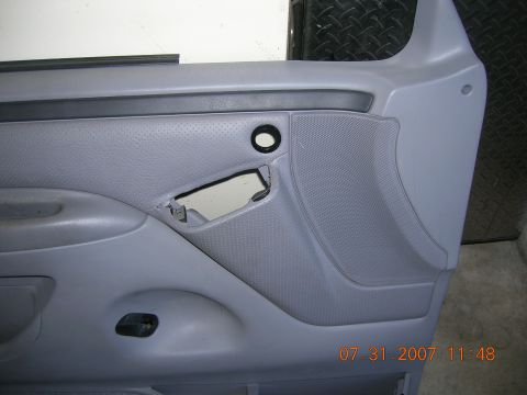 1996 Ford Bronco - The interior door panel shows a speaker grille and a cutout for the door handle mechanism.