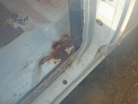 1986 Ford Bronco - The interior door frame of a vehicle shows significant rust and corrosion, indicating wear and tear.