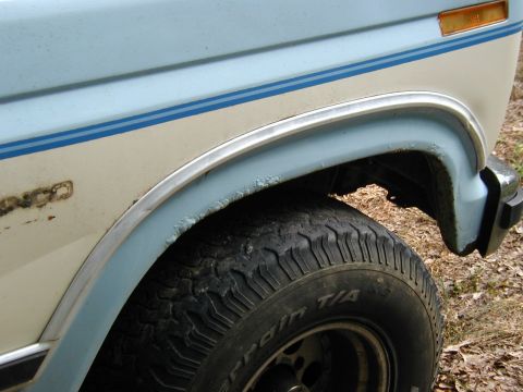 1986 Ford Bronco - Close-up of the fender and tire on a 1986 Ford Bronco, a two-tone blue and cream paint scheme.