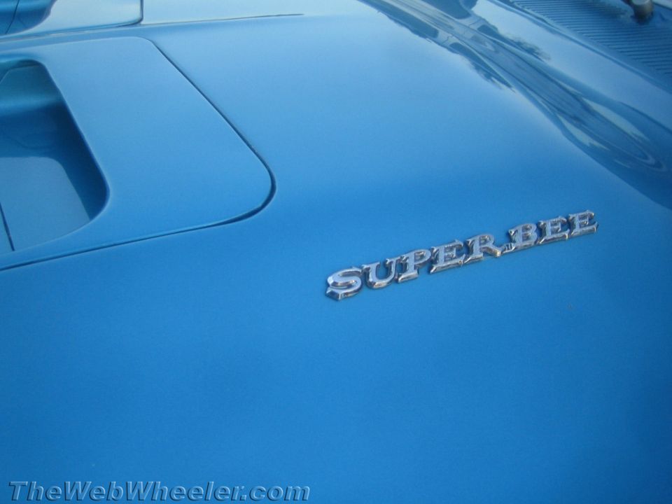 Blue car hood with chrome 'SUPER BEE' emblem and a vent